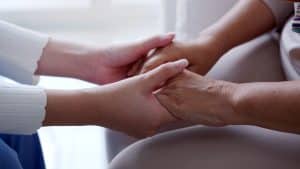 Close up hand of young asia woman or nurse home care holding senior