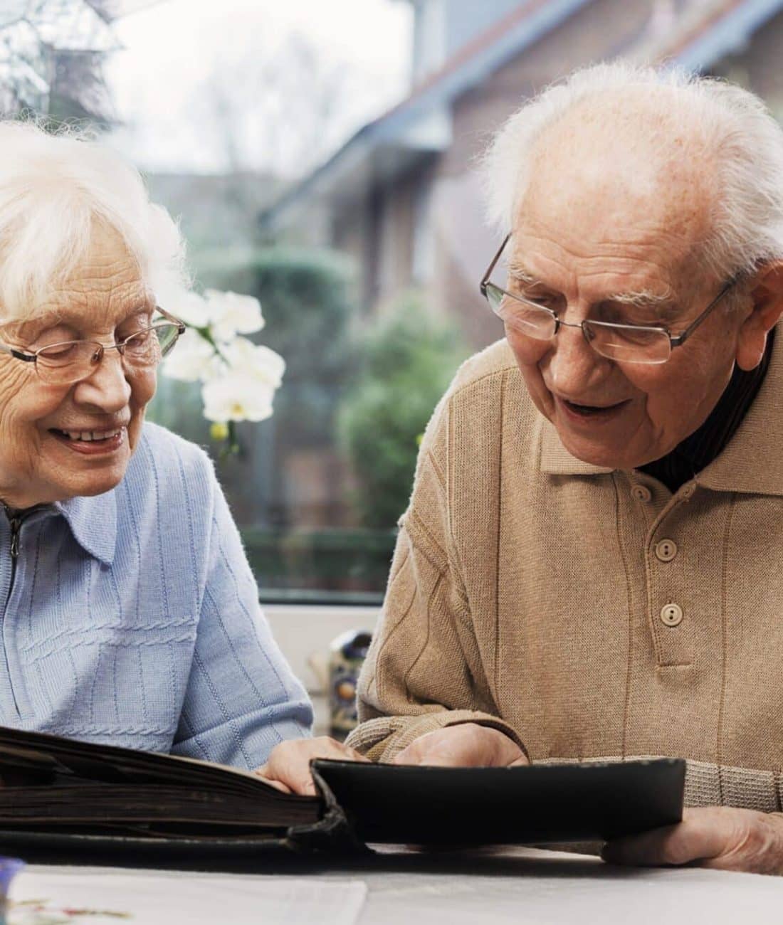 Senior couple watching old photographs at home